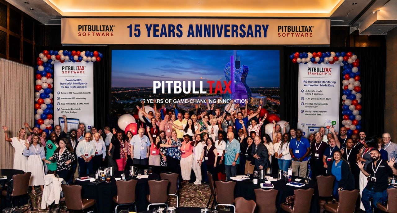 The PitBullTax community on stage with hands raised at the 15th Anniversary celebration.