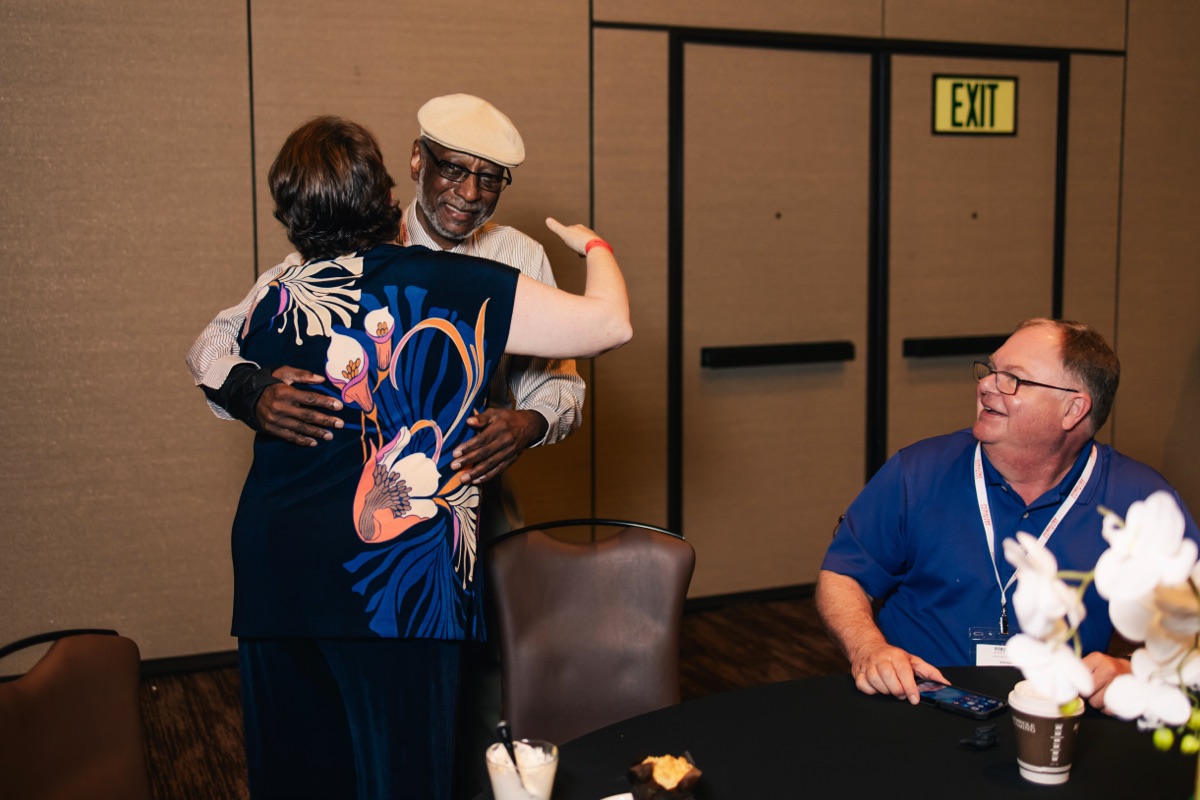 Two attendees greeting each other at a PitBullTax® conference networking moment.