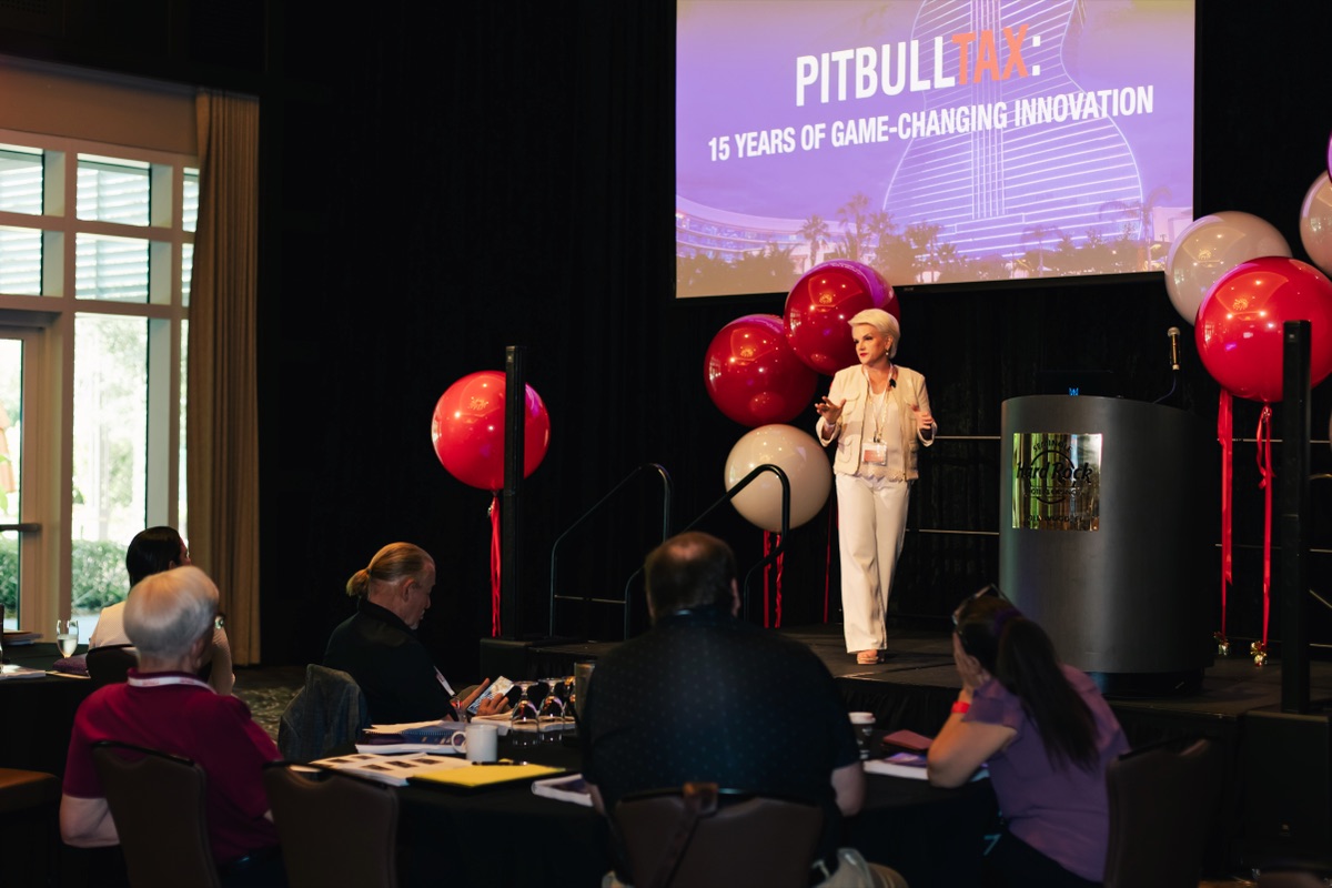Instructor presenting at the PitBullTax® conference, audience taking notes.