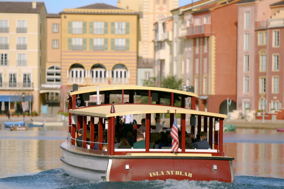 Loews Portofino Bay Hotel water taxi crossing the harbor with the Italian-village façades behind.